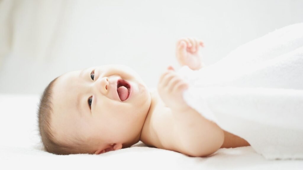 Baby sleeping safely on a non-toxic organic crib mattress with breathable cotton sheets